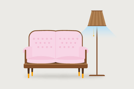 a pink sofa next to a floor lamp